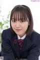 A woman in a school uniform posing for a picture.