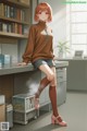 A girl sitting on a desk in front of a book shelf.