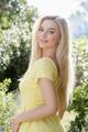 A woman in a yellow dress posing for a picture.