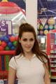 A woman standing in front of a candy store.