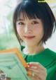 A woman in a green dress holding a book.