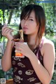 A woman eating a bowl of noodles with a spoon.