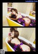 A woman in a bathtub with flowers in her hair.