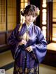 A woman in a purple kimono posing for a picture.